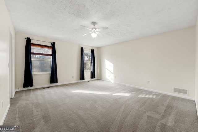 spare room with a healthy amount of sunlight, light colored carpet, and ceiling fan