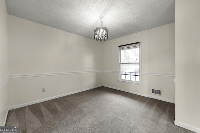 unfurnished room with carpet flooring, a textured ceiling, and a chandelier