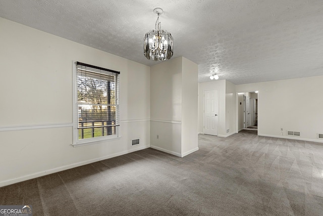 unfurnished room featuring a chandelier, carpet, and a textured ceiling