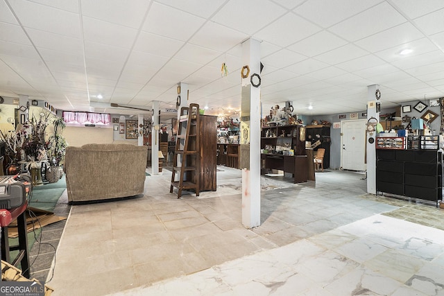 basement with marble finish floor and a drop ceiling