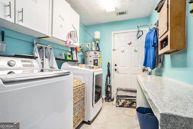 clothes washing area featuring cabinet space, visible vents, a textured ceiling, washing machine and dryer, and water heater