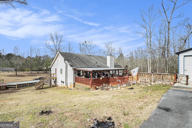 exterior space with a chimney, fence, a deck, and a yard