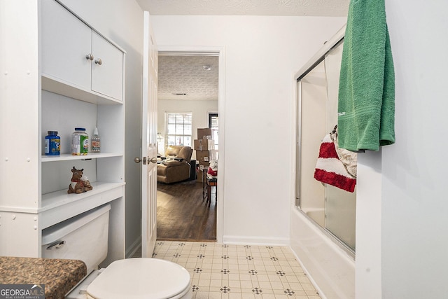 bathroom featuring a textured ceiling, shower / bath combination with glass door, toilet, and tile patterned floors