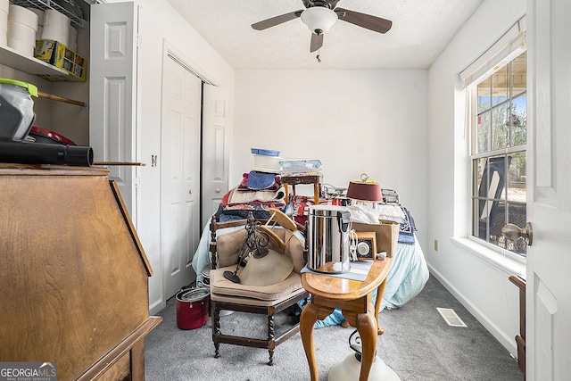 home office with a textured ceiling, carpet flooring, a ceiling fan, and baseboards