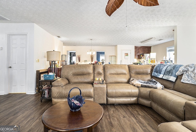 living area featuring a textured ceiling, dark wood-style flooring, and visible vents