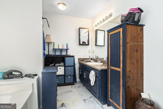 full bathroom featuring a textured ceiling, marble finish floor, and vanity