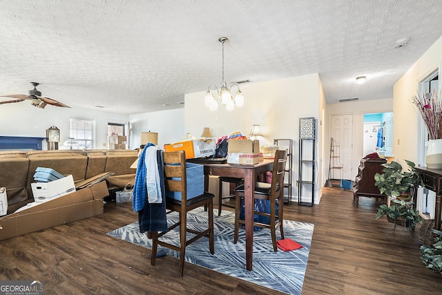 dining room featuring a textured ceiling, visible vents, wood finished floors, and ceiling fan with notable chandelier