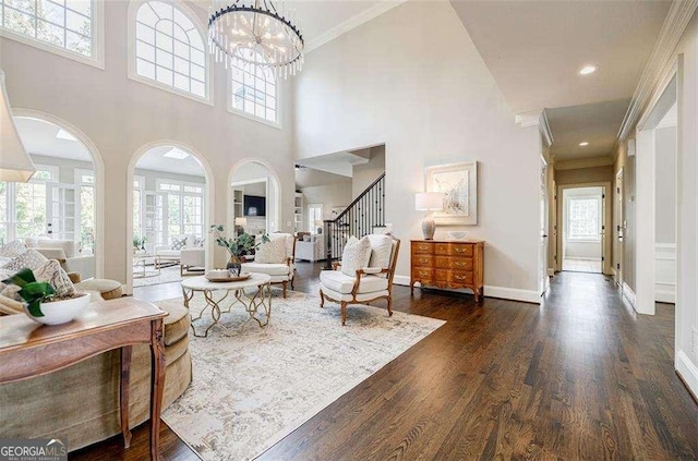 living room with crown molding, dark hardwood / wood-style floors, and an inviting chandelier