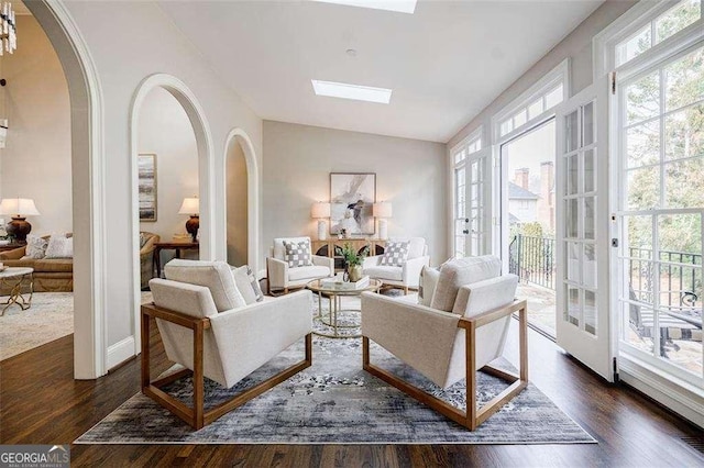 living room with dark wood-type flooring and a wealth of natural light