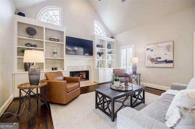 living room with high vaulted ceiling, a fireplace, and hardwood / wood-style floors