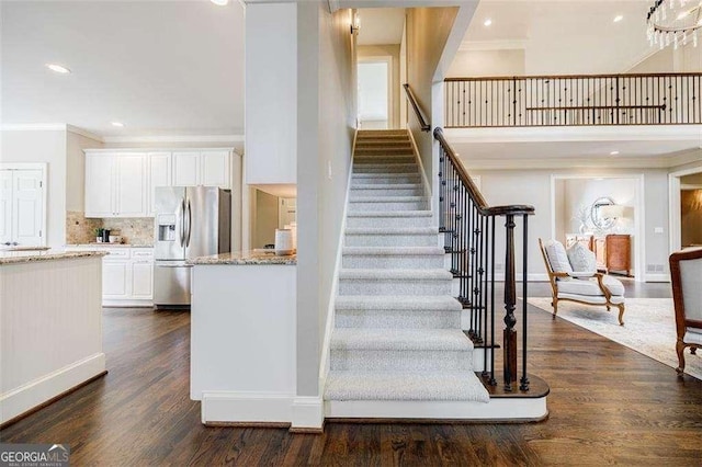 stairs featuring crown molding and hardwood / wood-style floors