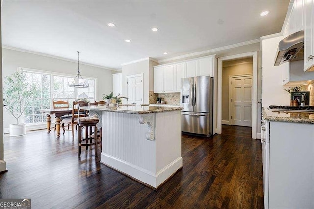 kitchen featuring stainless steel appliances, light stone countertops, extractor fan, and white cabinets