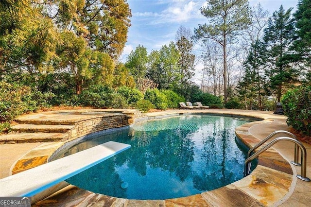 view of swimming pool featuring a diving board