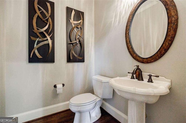 bathroom with hardwood / wood-style flooring and toilet