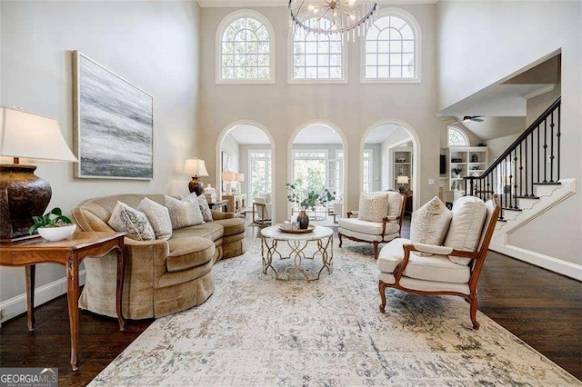 living room with a healthy amount of sunlight, dark hardwood / wood-style floors, and a chandelier