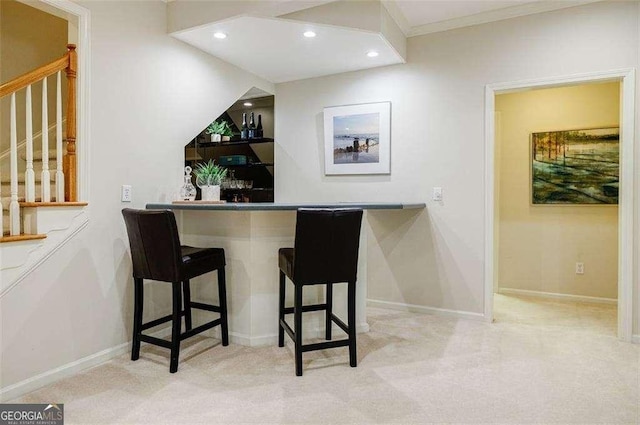 bar with ornamental molding and light colored carpet