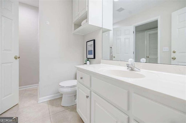 bathroom featuring vanity, tile patterned floors, and toilet