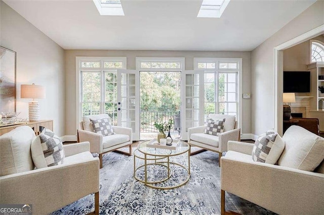 living room with hardwood / wood-style floors, a skylight, and plenty of natural light