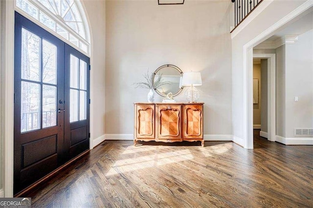 entrance foyer with a wealth of natural light, dark hardwood / wood-style flooring, and french doors