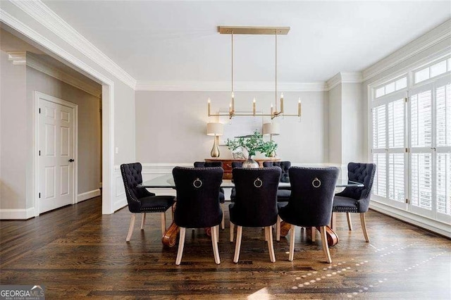 dining area featuring crown molding, dark hardwood / wood-style floors, and a chandelier