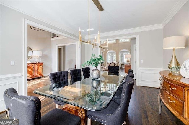 dining area featuring ornamental molding, dark hardwood / wood-style flooring, and a chandelier