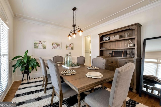 dining room featuring hardwood / wood-style floors and crown molding