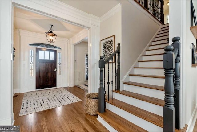 entrance foyer featuring crown molding and wood-type flooring