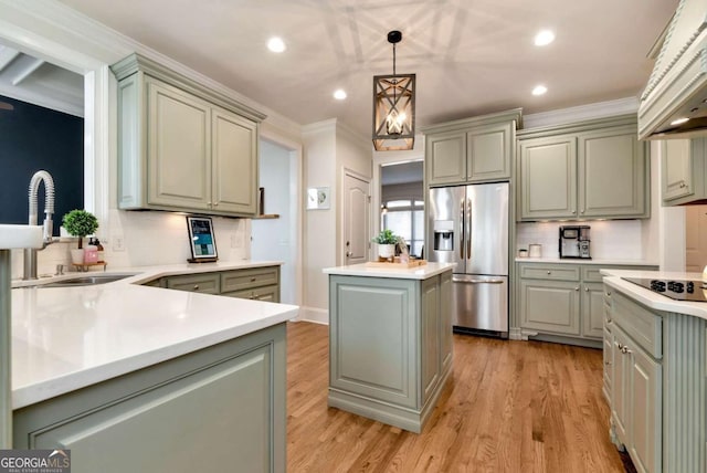 kitchen with sink, a center island, black electric cooktop, stainless steel fridge with ice dispenser, and decorative light fixtures