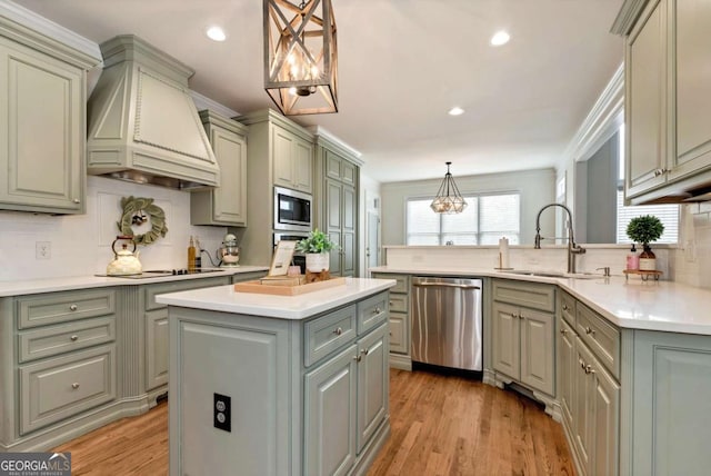 kitchen with sink, custom exhaust hood, appliances with stainless steel finishes, kitchen peninsula, and a kitchen island