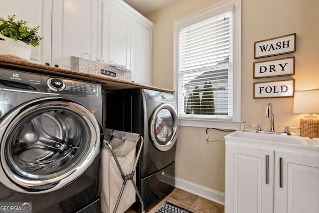 laundry area with cabinets, sink, tile patterned flooring, and washing machine and clothes dryer