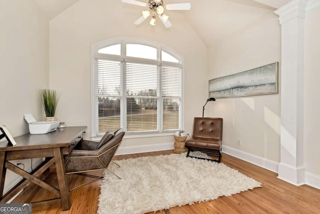 office space featuring hardwood / wood-style flooring, vaulted ceiling, ceiling fan, and ornate columns