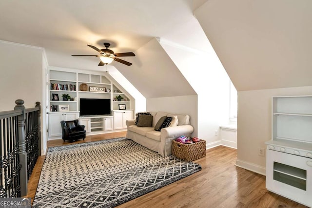 living room featuring lofted ceiling, hardwood / wood-style floors, ceiling fan, and built in shelves