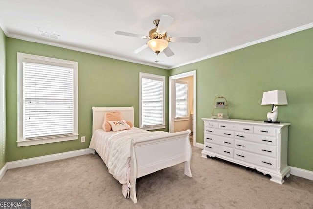 carpeted bedroom with ceiling fan and ornamental molding