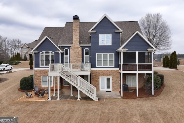 rear view of property featuring a patio area, a sunroom, and a deck