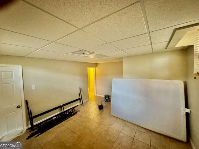 interior space with light tile patterned flooring and a paneled ceiling