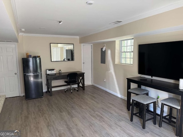 home office featuring hardwood / wood-style flooring, ornamental molding, and electric panel