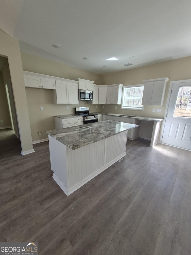 kitchen featuring plenty of natural light, white cabinets, appliances with stainless steel finishes, and dark wood-style flooring