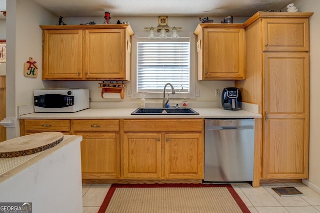 kitchen featuring light tile patterned flooring, sink, and stainless steel dishwasher