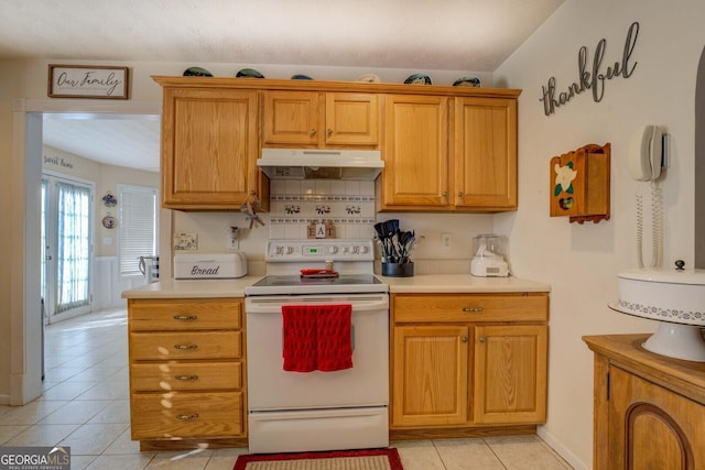 kitchen with light tile patterned flooring and white range with electric stovetop