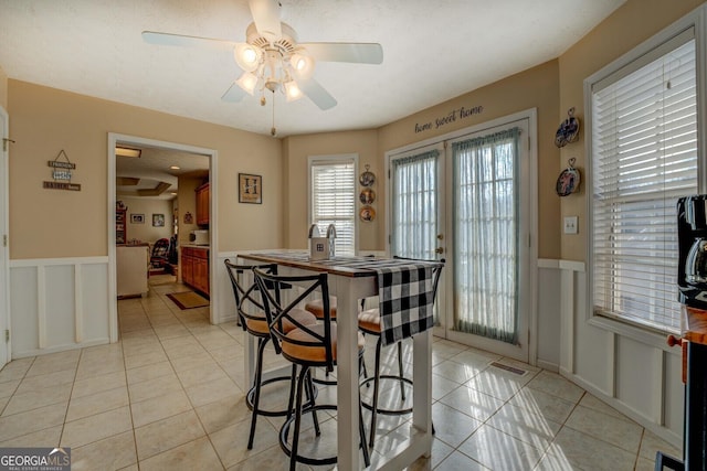 tiled dining room featuring french doors and ceiling fan