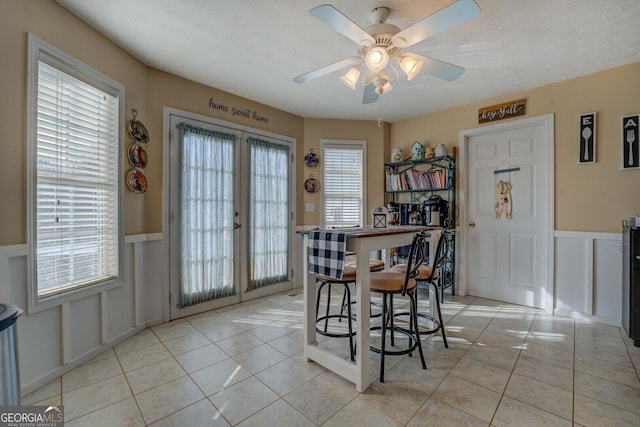 tiled dining room featuring french doors and ceiling fan