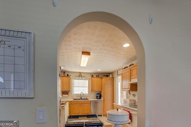 kitchen with light brown cabinetry, white electric stove, dishwasher, sink, and a textured ceiling