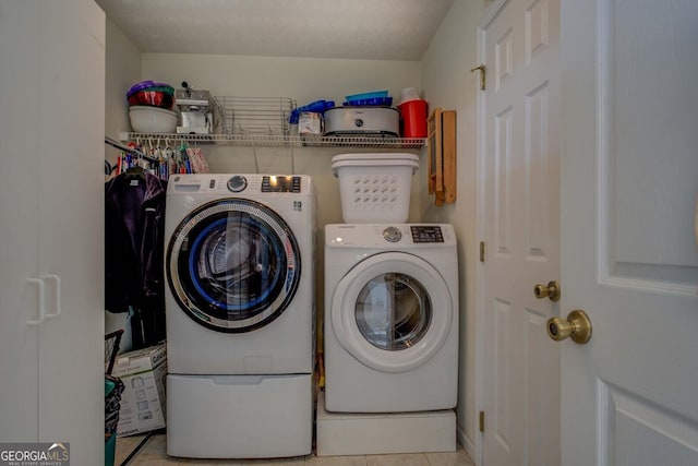 laundry area featuring washing machine and dryer and light tile patterned floors