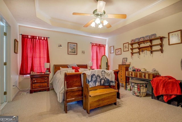 bedroom featuring crown molding, carpet floors, a raised ceiling, and ceiling fan