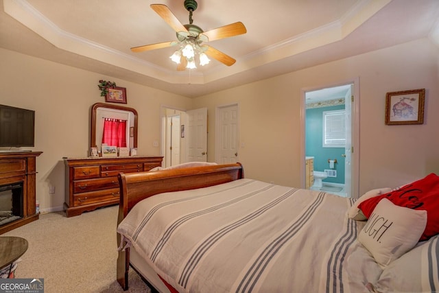 carpeted bedroom featuring ensuite bathroom, ceiling fan, ornamental molding, and a raised ceiling