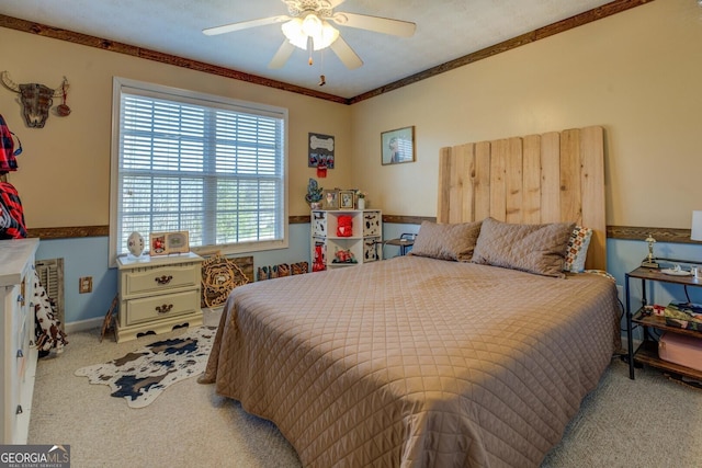 carpeted bedroom featuring ornamental molding and ceiling fan