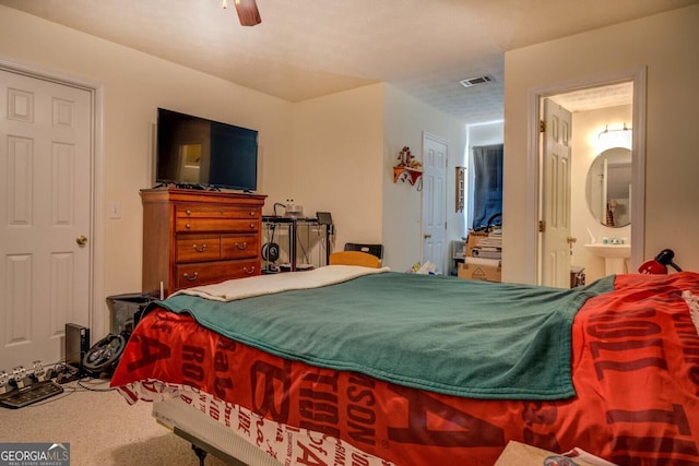 carpeted bedroom with ceiling fan and connected bathroom