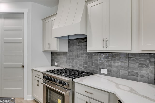 662 Lake Circle Rd, Buchanan, GA 30113 - kitchen with high end range, premium range hood, tasteful backsplash, and light stone countertops