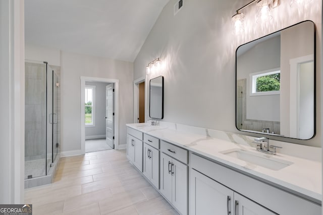 662 Lake Circle Rd, Buchanan, GA 30113 - bathroom with a stall shower, vaulted ceiling, double vanity, and baseboards