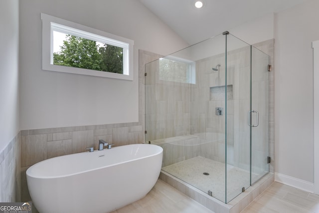 662 Lake Circle Rd, Buchanan, GA 30113 - bathroom featuring plenty of natural light, tile walls, a stall shower, a soaking tub, and vaulted ceiling